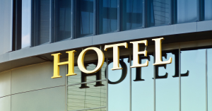 A hotel sign reflected in the glass of the building
